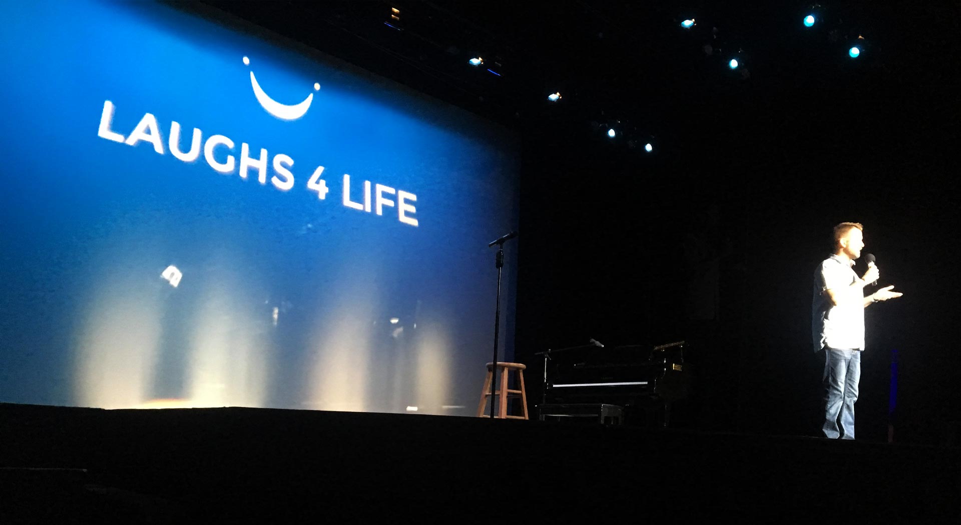Comedian onstage at Laughs4Life fundraiser