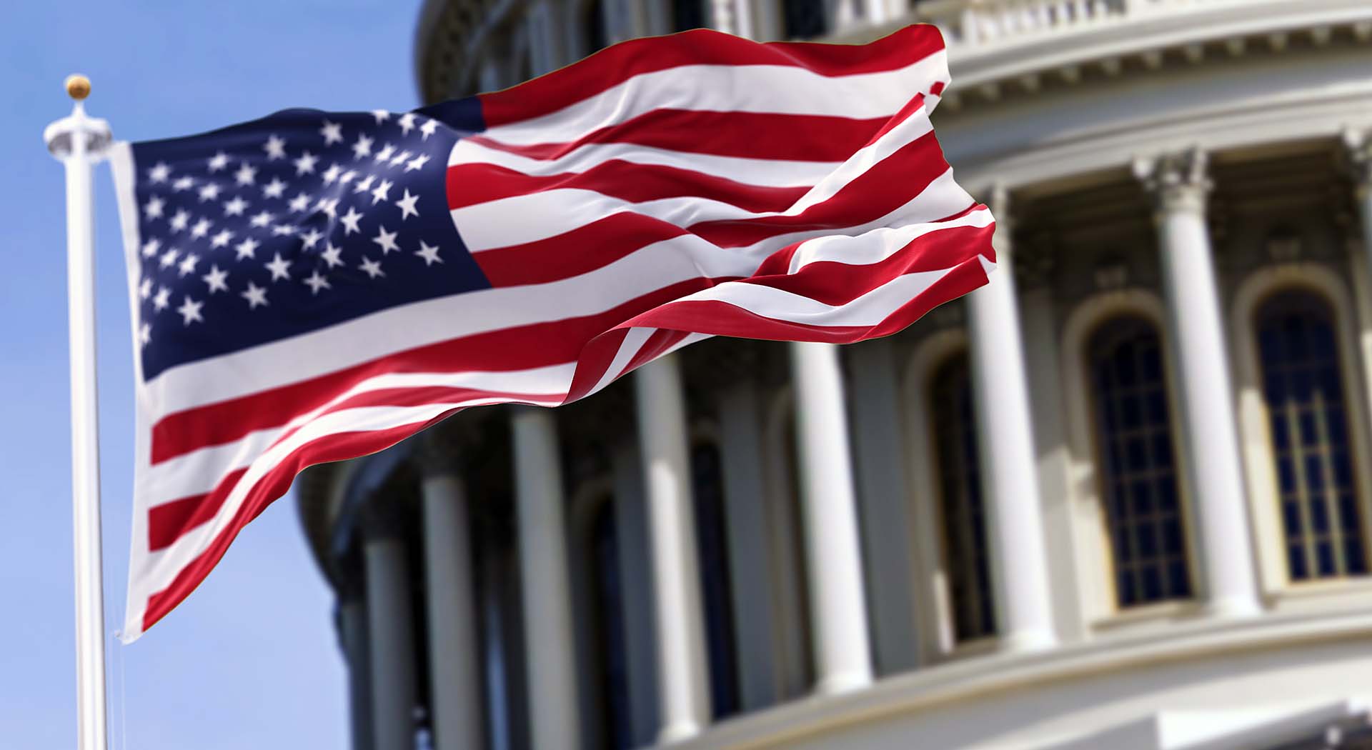American flag waving in the wind and legislative building