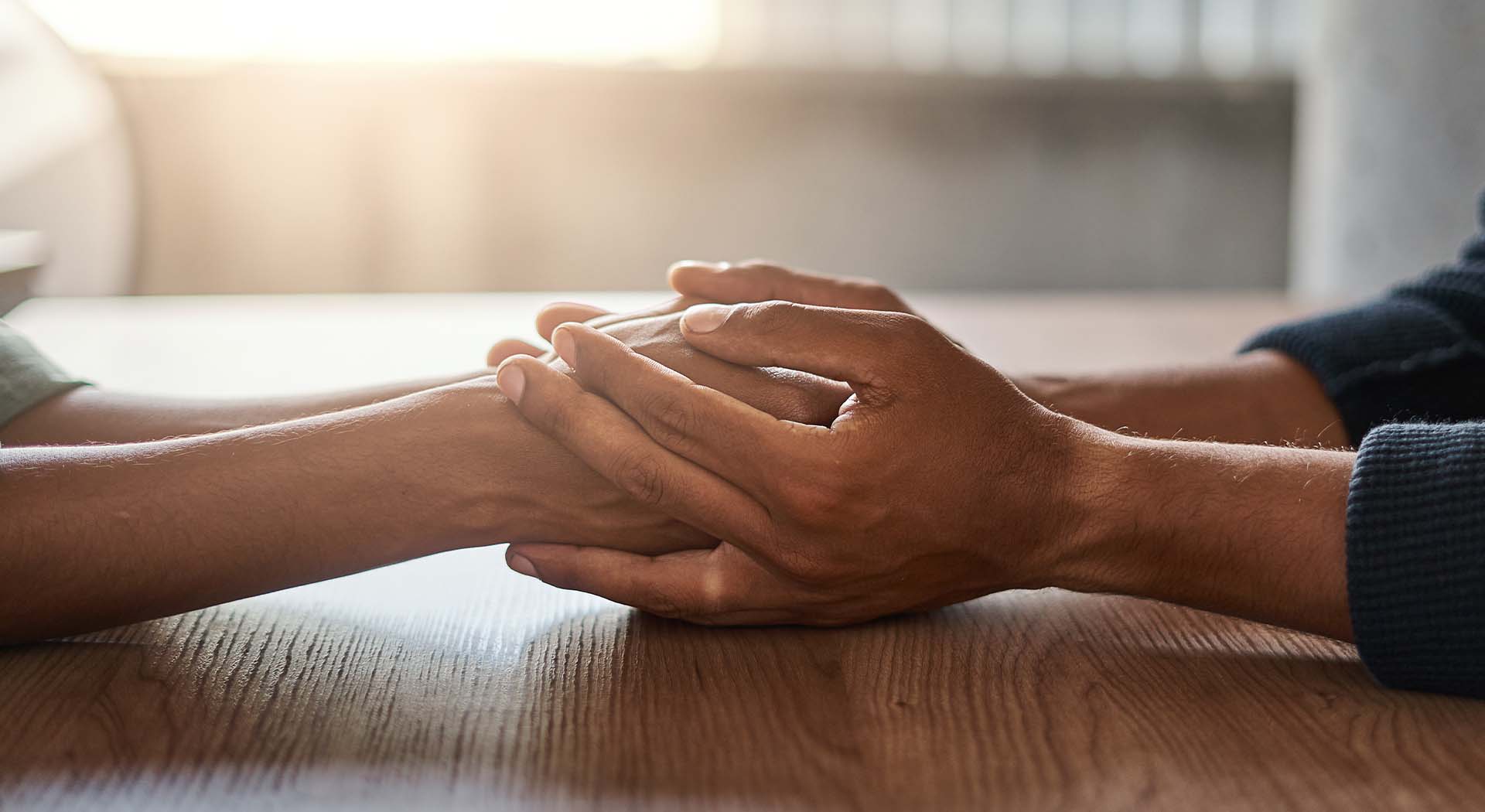 Closeup of holding hands across a table
