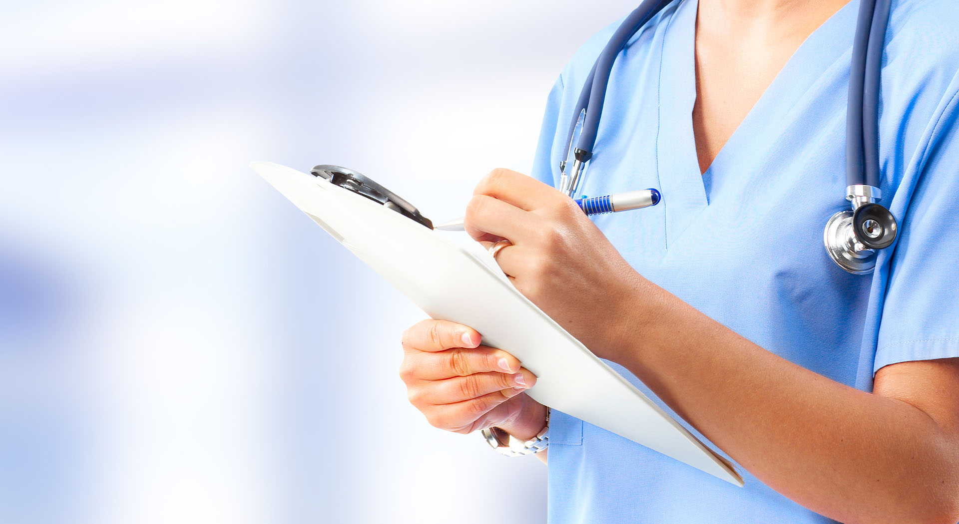Nurse in scrubs with clipboard