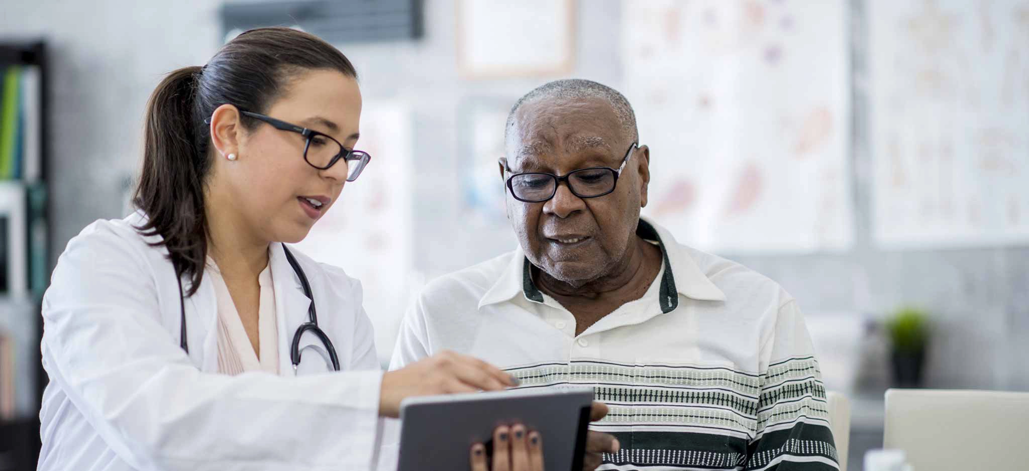 A doctor gives a patient a medical pamphlet during his doctor visit