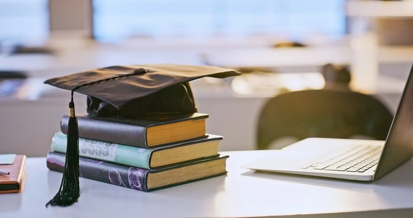 mortar board books and a computer
