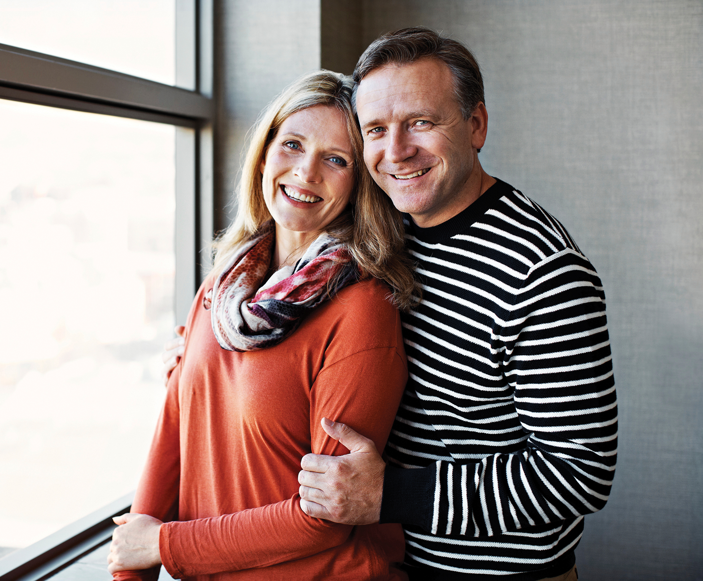 couple standing next to window