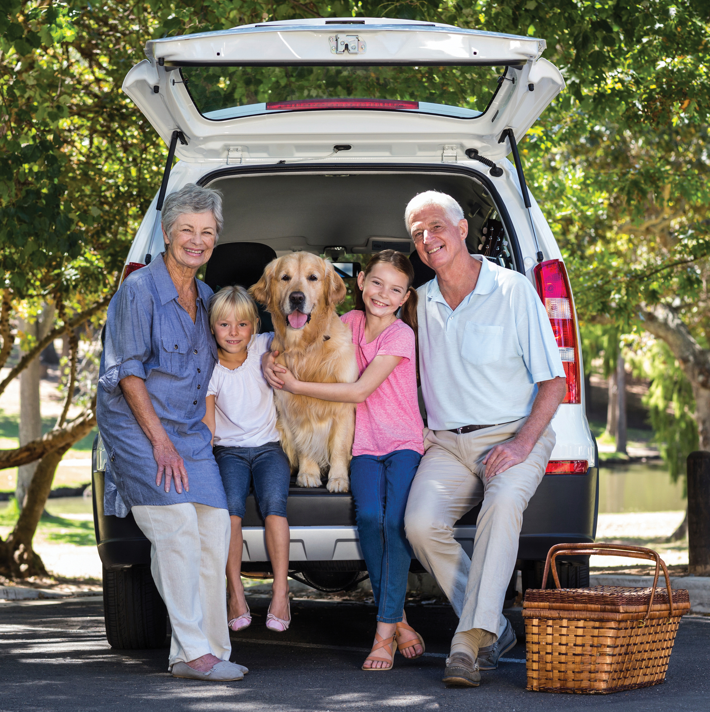 family sitting on trunk of van