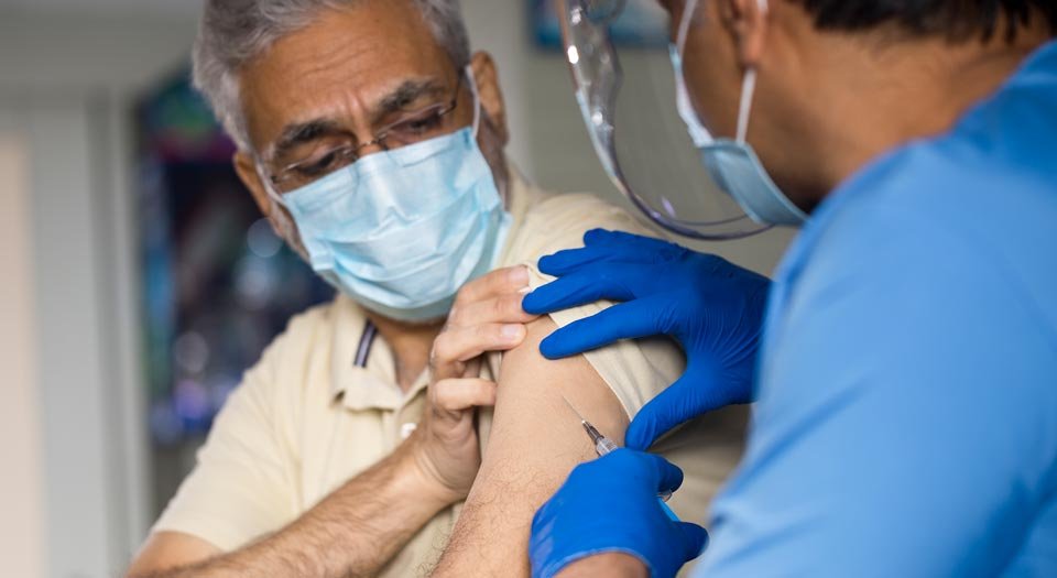 An elderly myeloma patient receives a COVID-19 vaccination