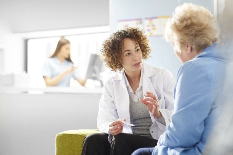 Female doctor talking to senior female patient