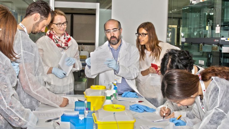 Researchers gather around a table.