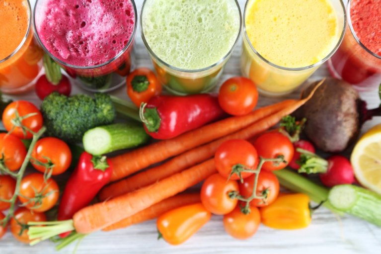 Colorful fruit smoothies and assorted vegetables