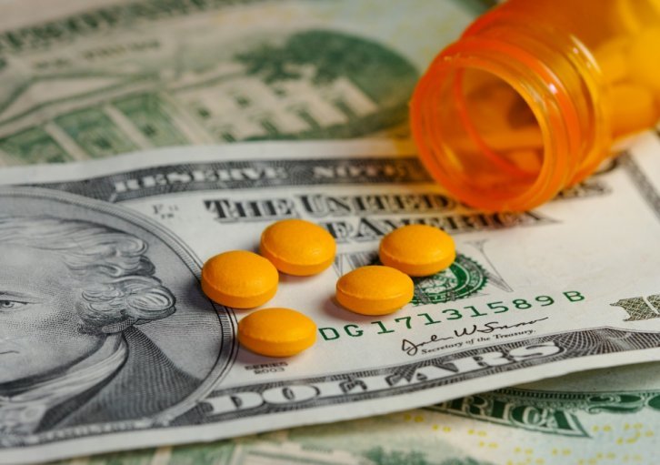 twenty dollar bill with prescription pills on top of it