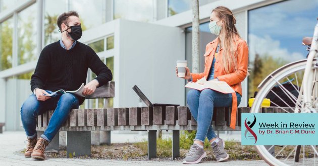 man and women on bench in masks