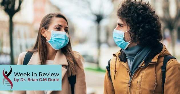 A couple talk outside while wearing masks