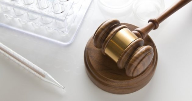 Judge's gavel along side medical research test tubes