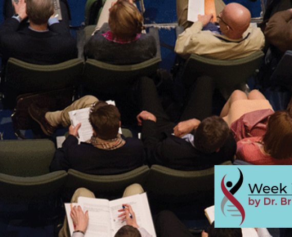 Overhead view of people sitting in chairs taking note