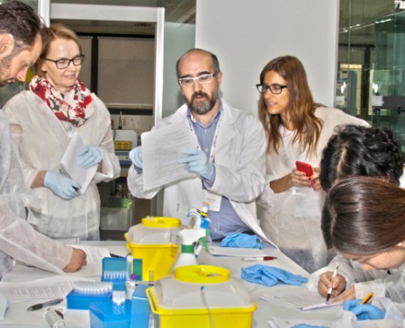 Researchers gather around a table. 