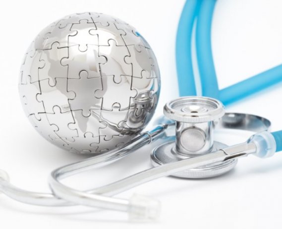 Silver dome made of puzzle pieces next to a blue stethoscope on a blue background