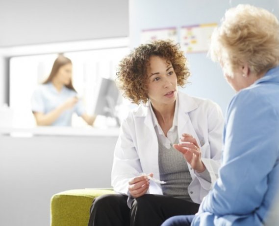 Female doctor talking to senior female patient