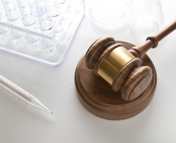 Judge's gavel along side medical research test tubes