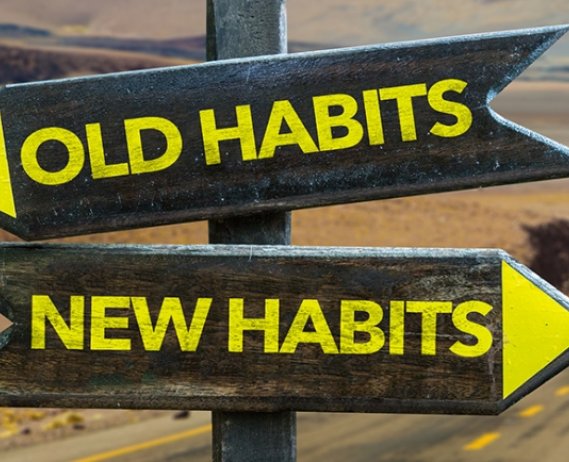 Image of a road sign, one way pointing to old habits, one way pointing to new habits
