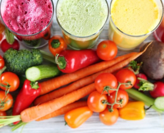 Colorful fruit smoothies and assorted vegetables
