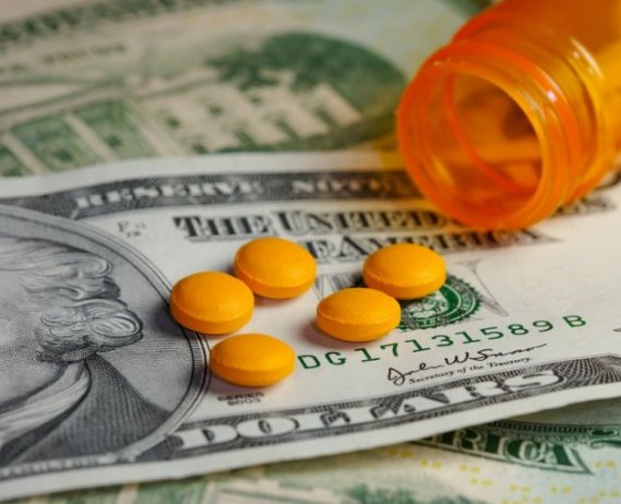 twenty dollar bill with prescription pills on top of it