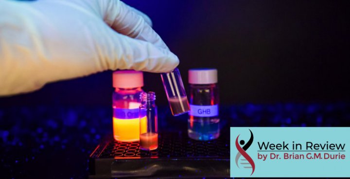 Hand in latex glove grabbing a vial