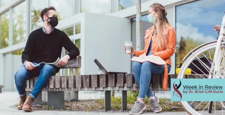 man and women on bench in masks