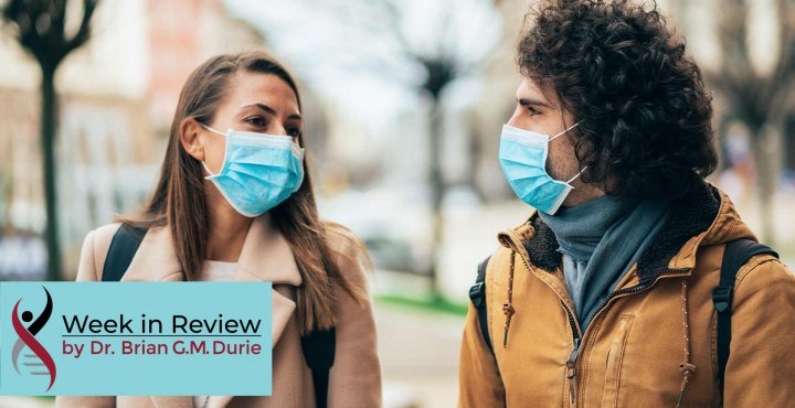 A couple talk outside while wearing masks