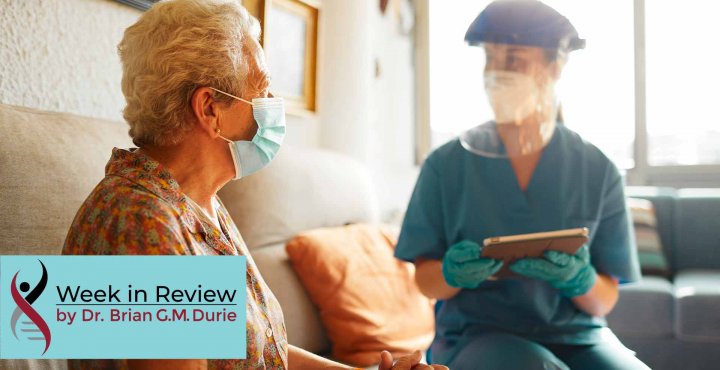 An elderly patient visits with a doctor equipped with full PPE protection
