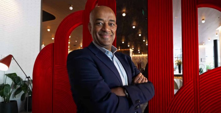Yelak Biru, IMF president, CEO, and 28-year myeloma patient, stands with his arms crossed at the IMF's 2024 GMAN Summit.