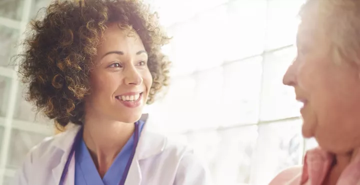 smiling doctor meets with patient