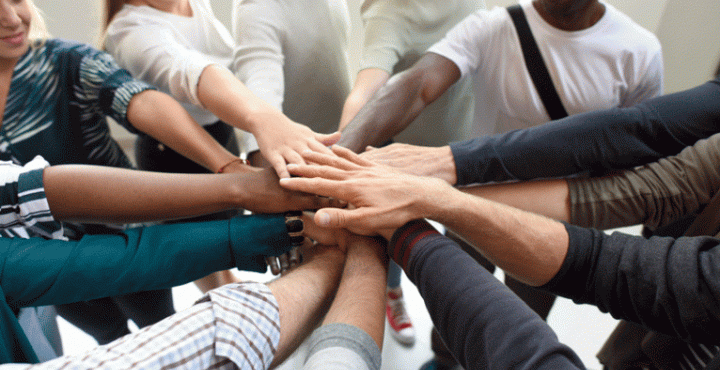Group of people put hands in a circle