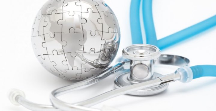Silver dome made of puzzle pieces next to a blue stethoscope on a blue background