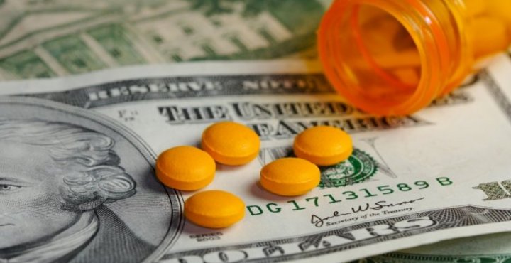 twenty dollar bill with prescription pills on top of it