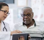A doctor gives a patient a medical pamphlet during his doctor visit