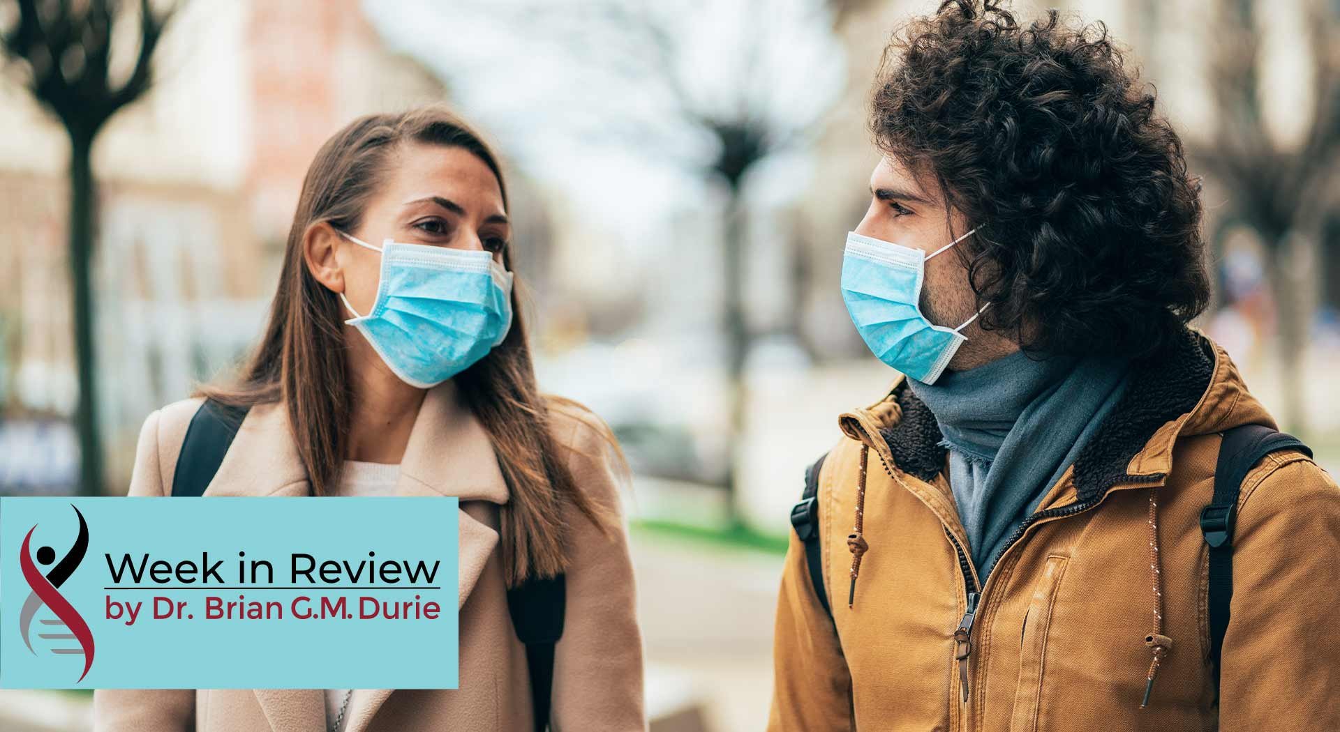 A couple talk outside while wearing masks