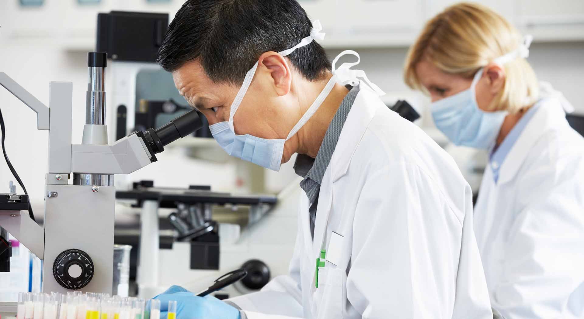 Asian scientist analyzes microscope sample