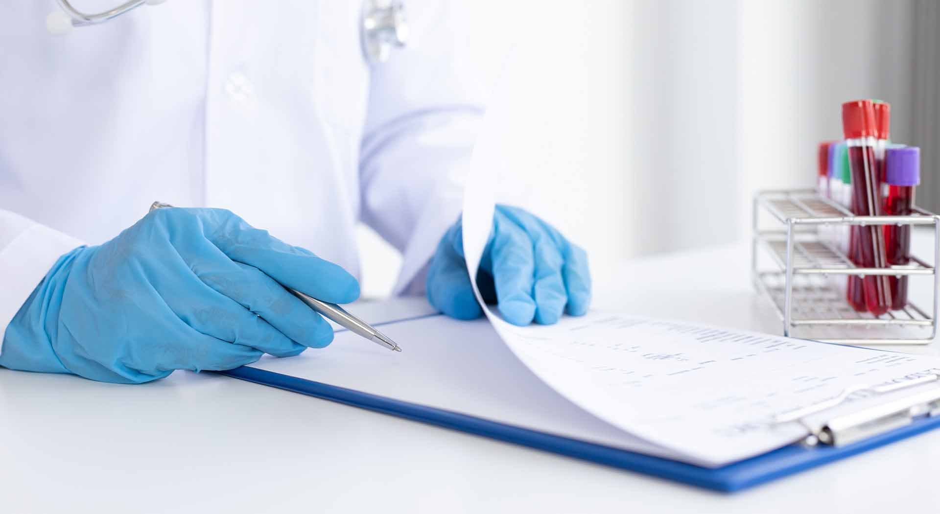 Scientist consults clipboard to analyze blood samples