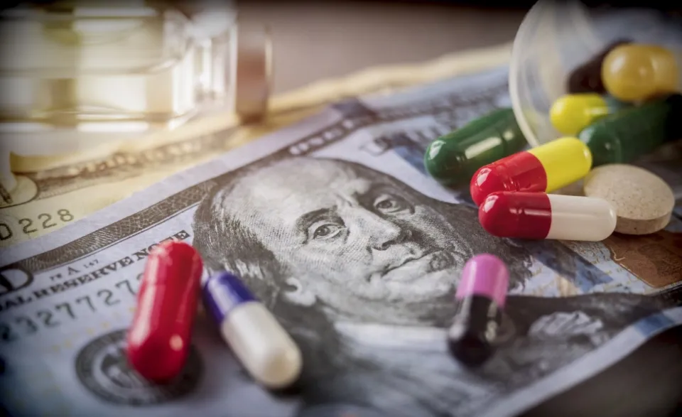50 dollar bill with pills on top of it