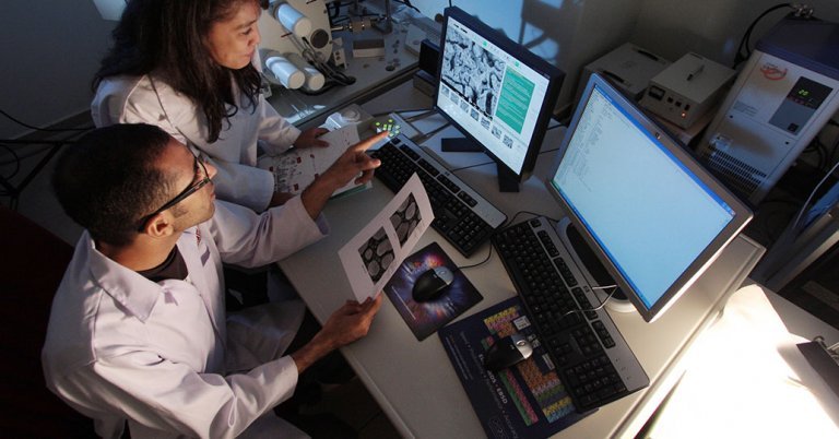 Two researchers look at computer screen