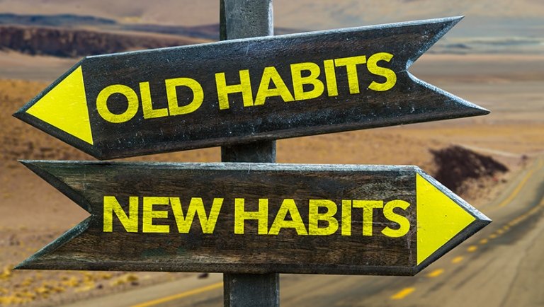 Image of a road sign, one way pointing to old habits, one way pointing to new habits